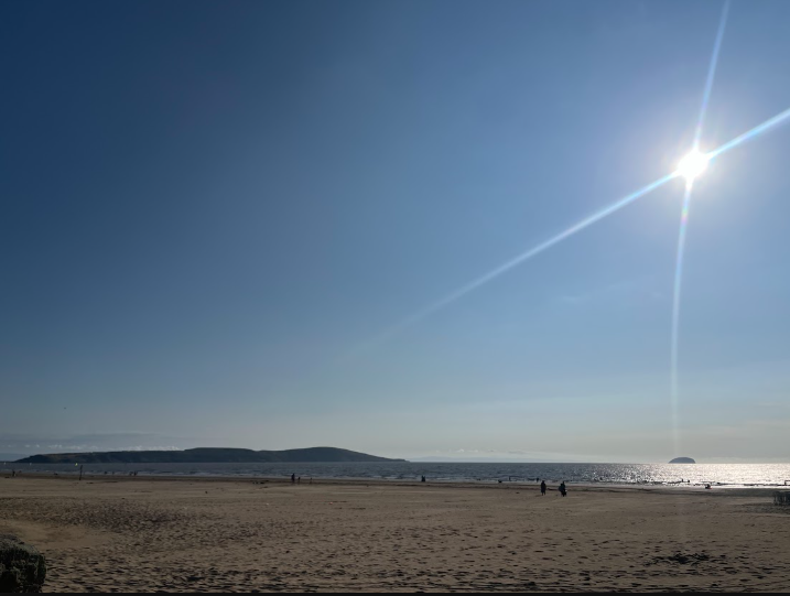 Tan Lines — sunny beach with distant mountains at Weston-Super-Mare